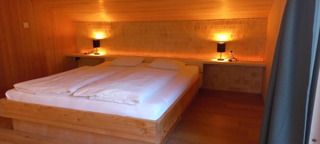 una camera da letto con un letto con due luci di Familienbauernhof Köss Schertler a Egg