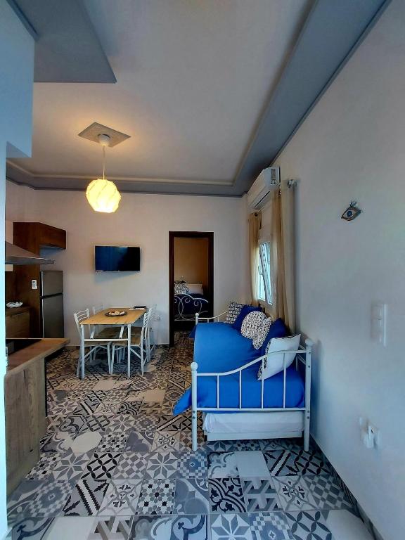 a living room with a blue couch and a table at Calliope#2 in Skala