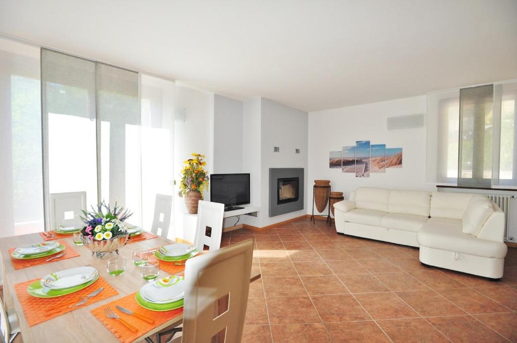 a living room with a table and a white couch at villa between lake and mountains in Valbrona