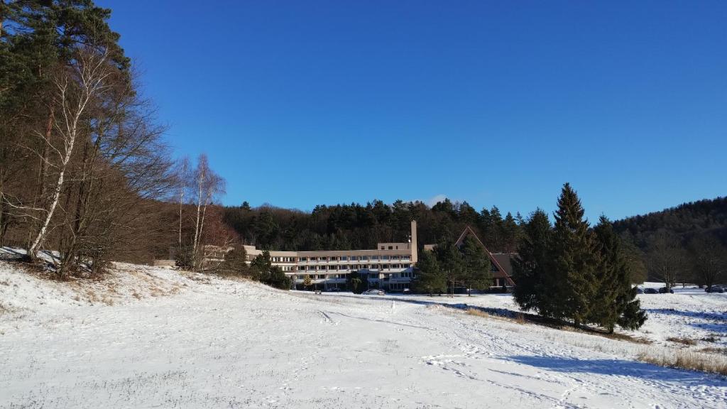 a snow covered road in front of a building at Apartmán Všemina 14A in Všemina
