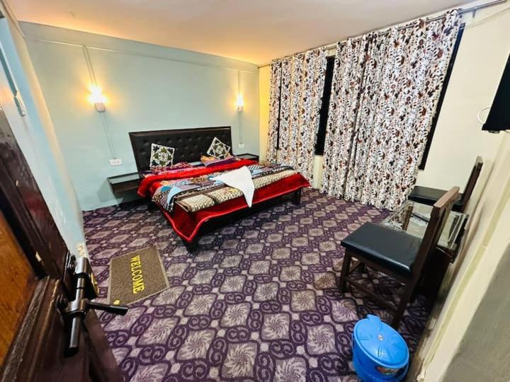 a bedroom with a bed and a chair in it at Dreamland Cottage in Pahalgām