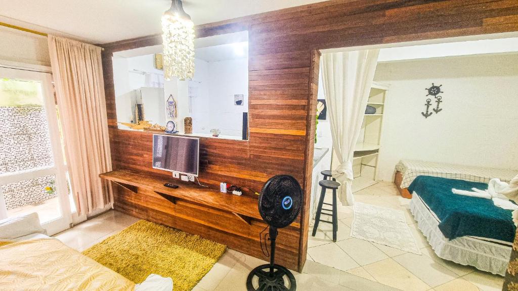 una camera da letto con una scrivania con una televisione e uno specchio di CASA COMPLETA 5min DA PRAIA JUQUEHY a São Sebastião