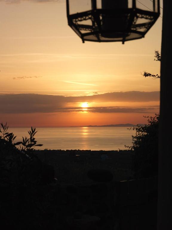 a sunset over the water with the sun in the sky at AFOURA HOUSES by K&K in Pyrgos