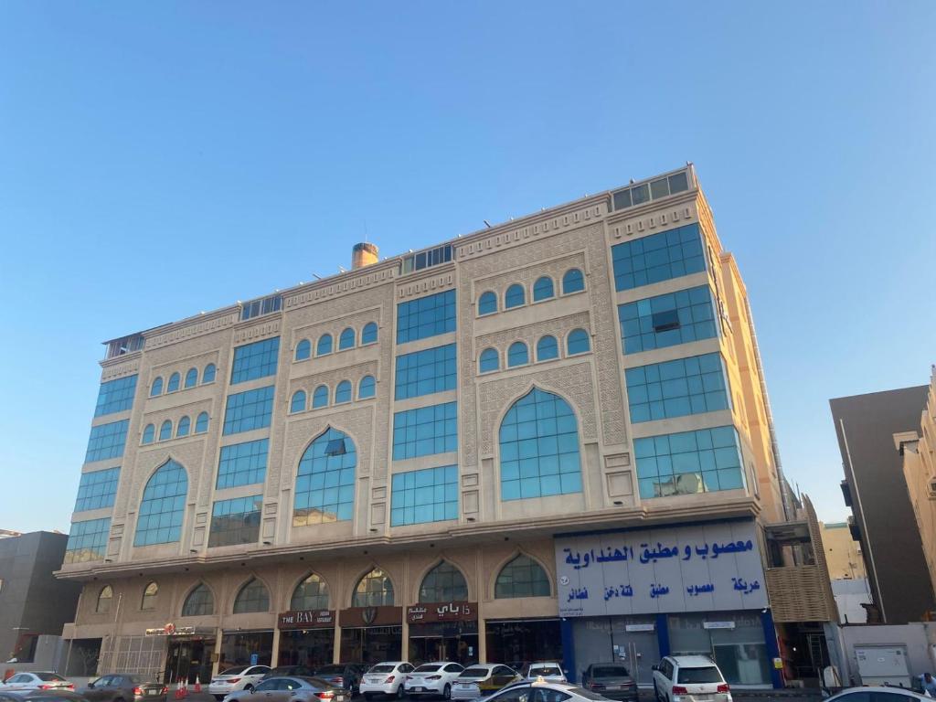 a large building with cars parked in a parking lot at Gardenia Park Quraish hotelفندق جاردينا بارك قريش in Jeddah