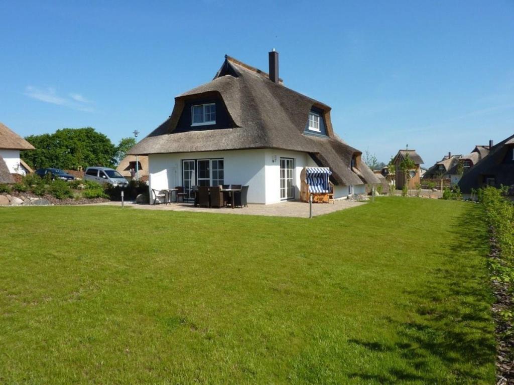 a house with a thatched roof with a yard at Reetdachhaus Windblume - super gemütlich in Zinnowitz