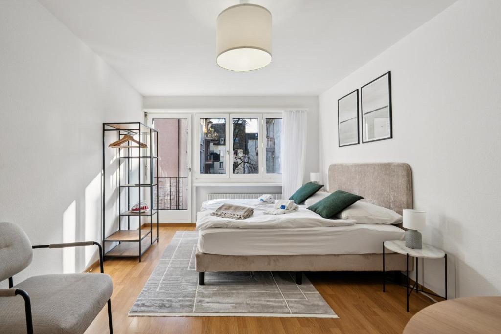 una camera da letto bianca con un letto e una finestra di City-Studio - sweet and modest - Crown 14 a Zurigo