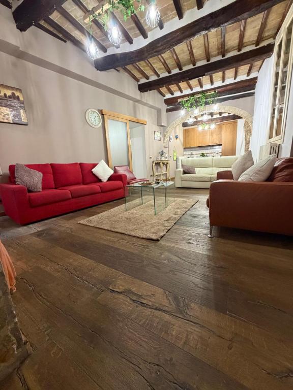 a living room with red couches and a table at Vicolo San rufino in Assisi