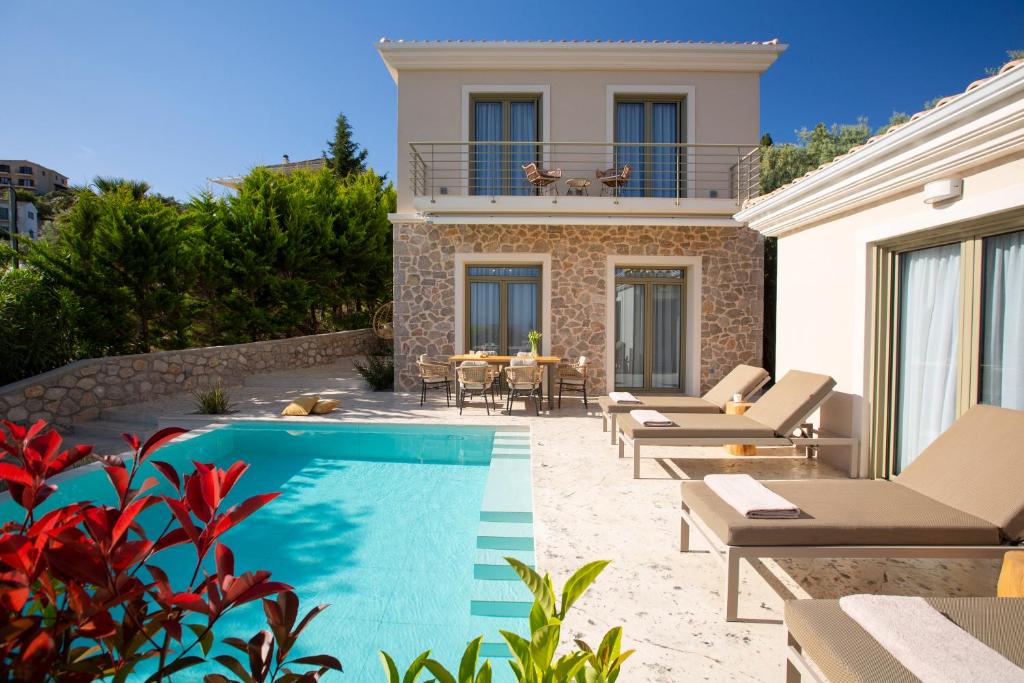 a villa with a swimming pool in front of a house at Veramente Villas With Sea view in Lefkada