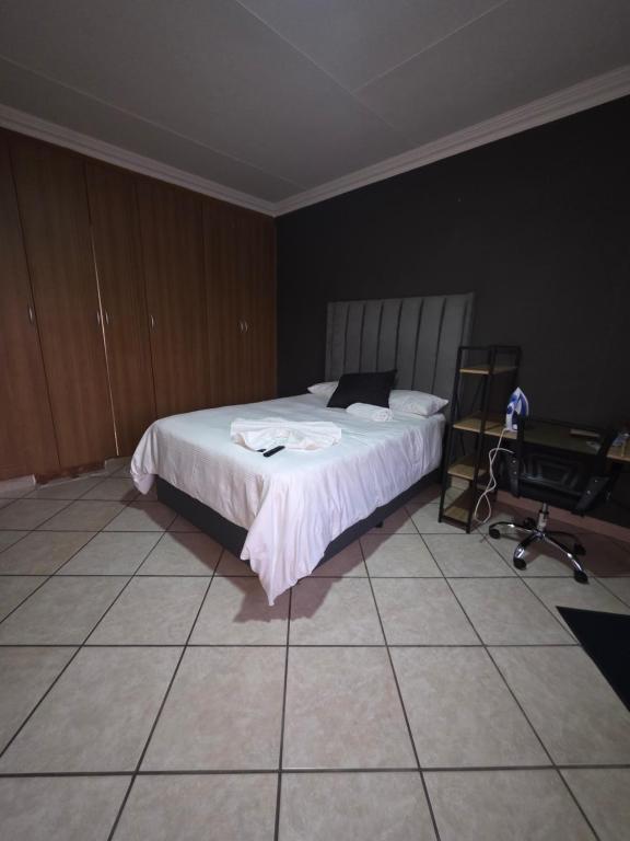 una camera da letto con un letto, una scrivania e una sedia di The Good Samaritan 3 a Witbank
