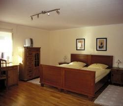 a bedroom with a large bed with a wooden headboard at Hotel Veltrup in Laer