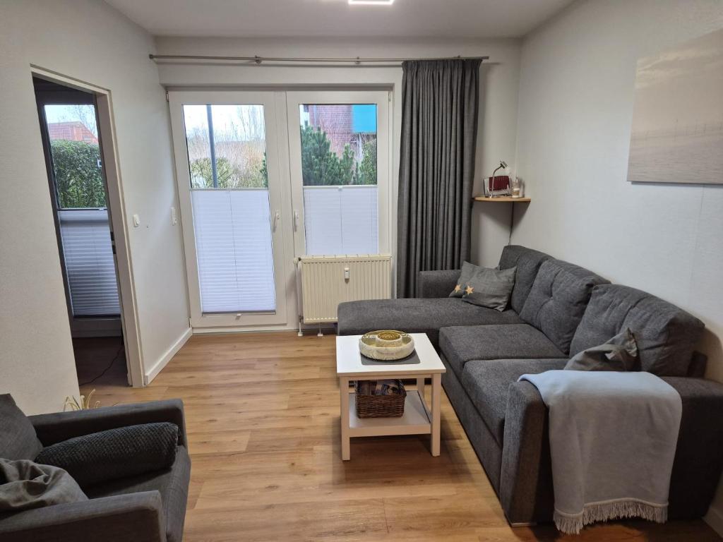 a living room with a couch and a table at Kleiner Mövenschiß in Dorum-Neufeld