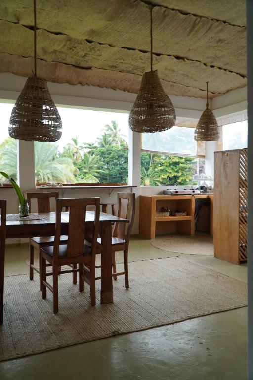 a dining room with a table and chairs and windows at Mlango Paje House II in Paje