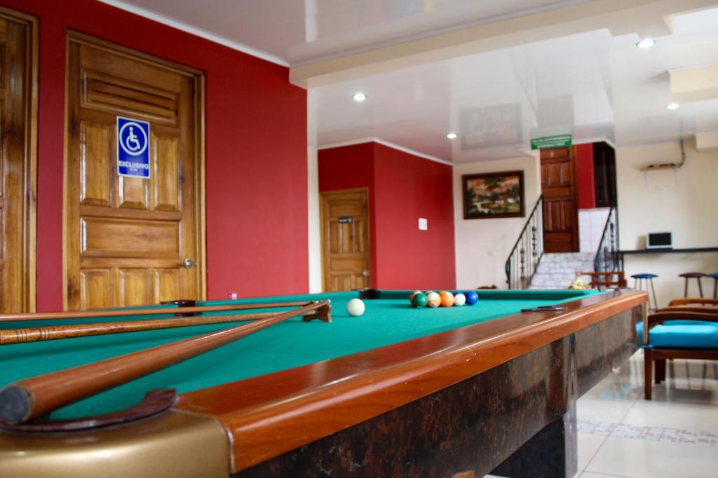einen Billardtisch in einem Zimmer mit roten Wänden in der Unterkunft Hotel Costa del Sol in Puerto Limón