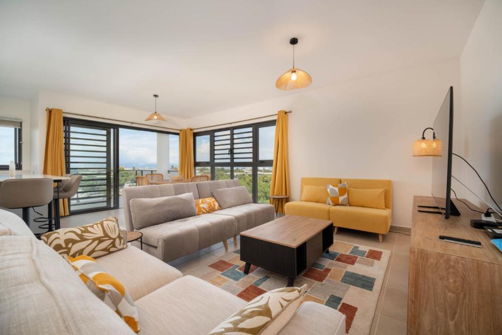 a living room with a couch and a tv at Laena Lodge in Papeete