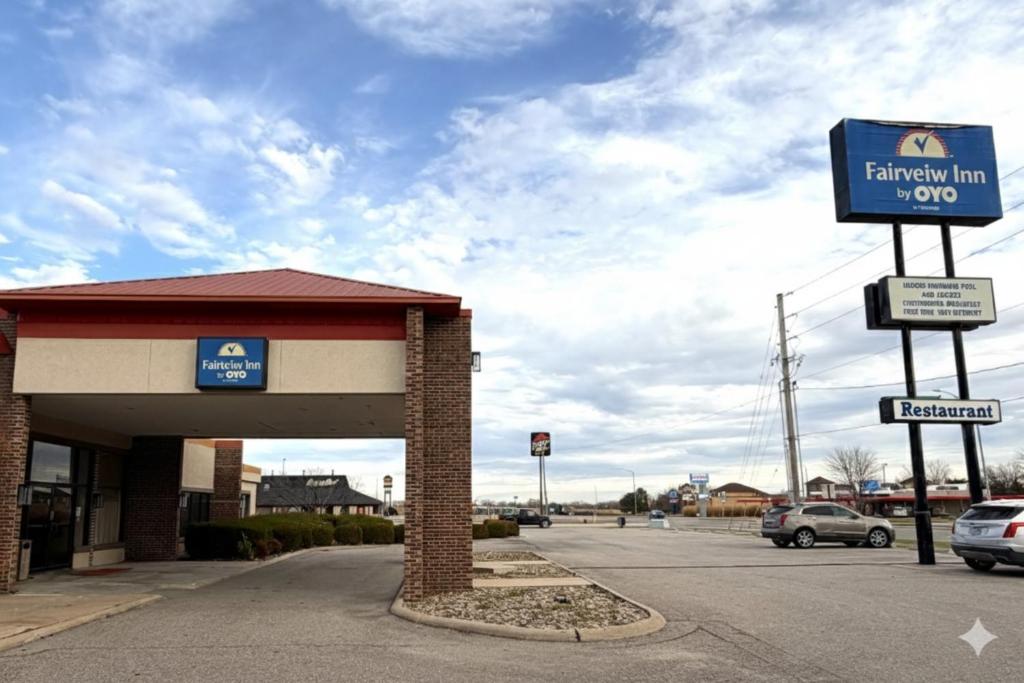 HesstonFairview Inn By OYO Hesston I-135的停车场内带有标志的加油站