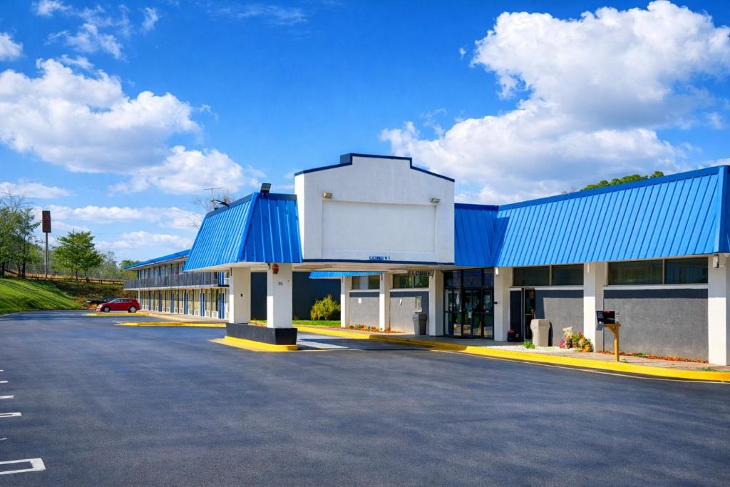 a large building with a blue roof and a parking lot at Heritage Inn Cartersville in Cartersville