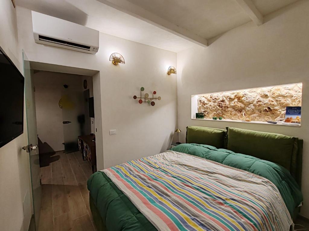 una piccola camera da letto con un letto e una finestra di Appartamento alla Immacolata Noto Centro Storico a Noto