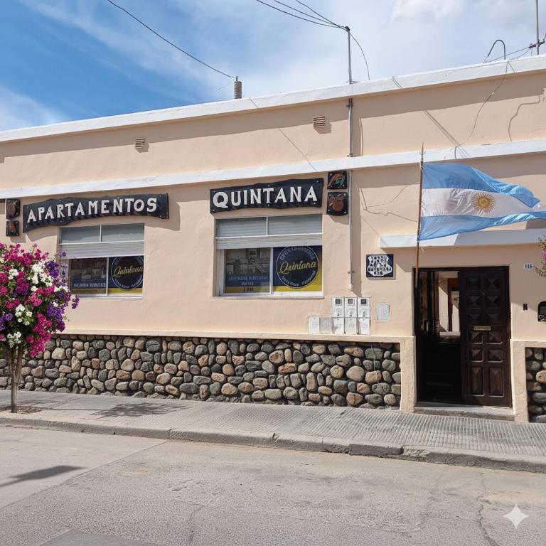 a building on a street with a flag on it at Apartamentos Quintana in Santa María