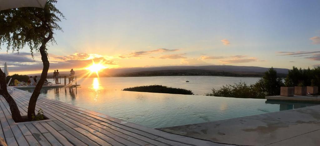a sunset over a large body of water at PUEBLO CHICO - casas de lago in Villa Ciudad de América