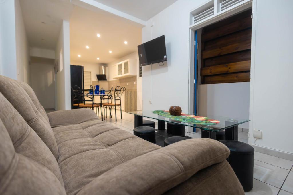 a living room with a couch and a table at Kanelle in Baie-Mahault