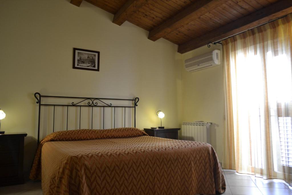 um quarto com uma cama e uma grande janela em Al Galileo Siciliano em Palermo