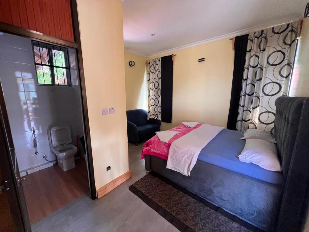 een kleine slaapkamer met een bed en een badkamer bij Steven and Dayness homestay in Lushoto