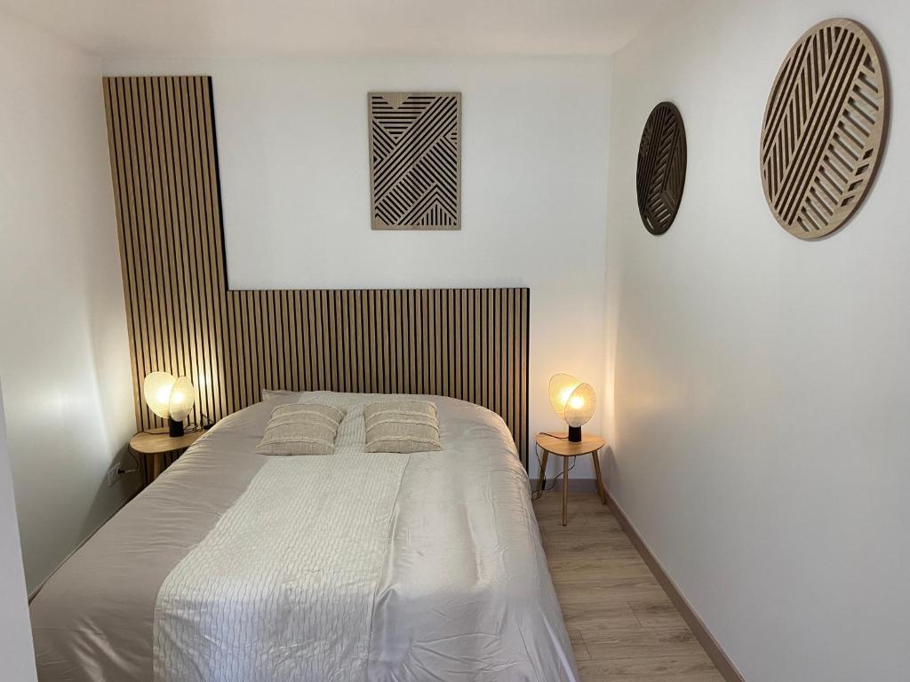 a bedroom with a bed with two lamps on two tables at Chambre double centre ville Bergerac in Bergerac