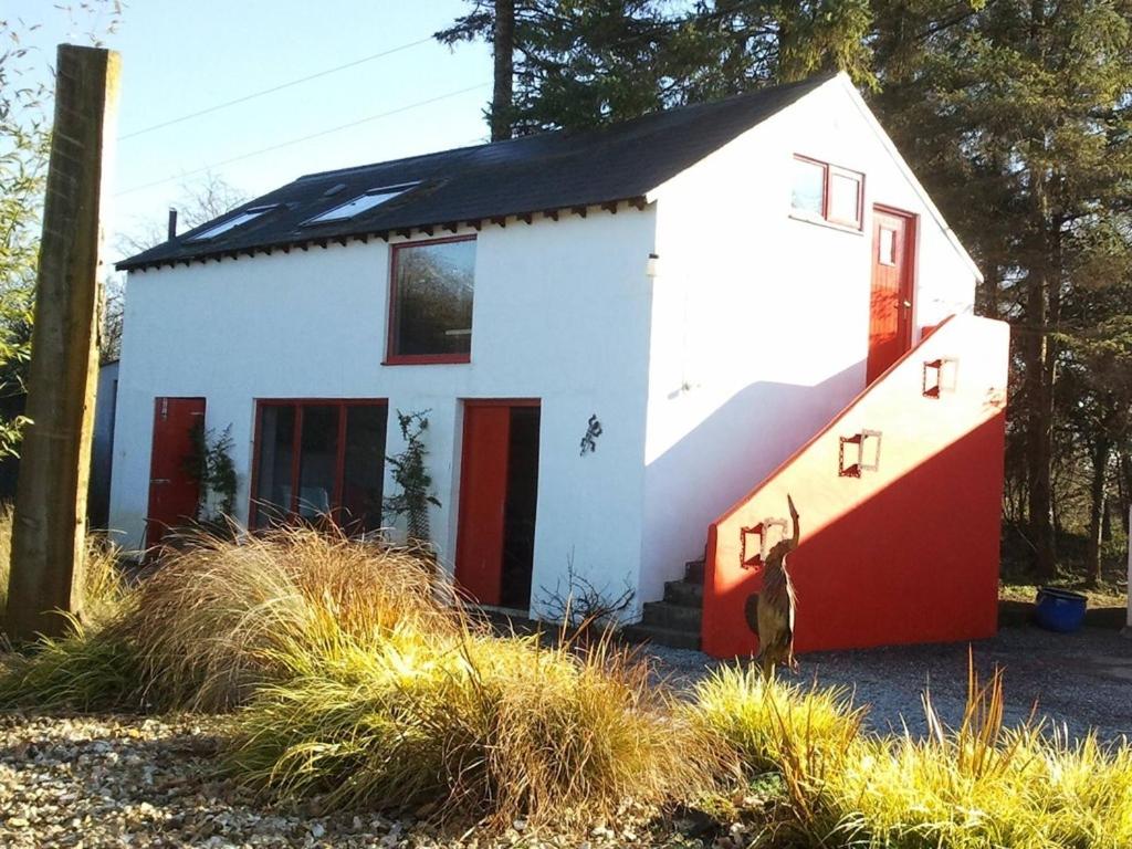 a small house with a red and white at The Village Studio Apartments in Moate