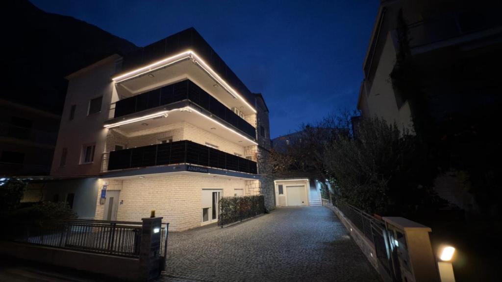 a large white building with a lit up facade at night at Apartments Neven in Omiš