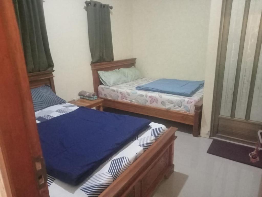 two twin beds in a room with a window at Safira in Ngadisari