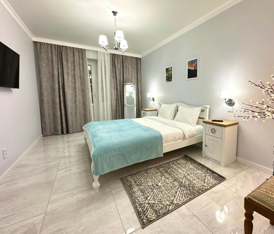a bedroom with a bed and a tv in it at Апартаменти La Storia in Kamianets-Podilskyi