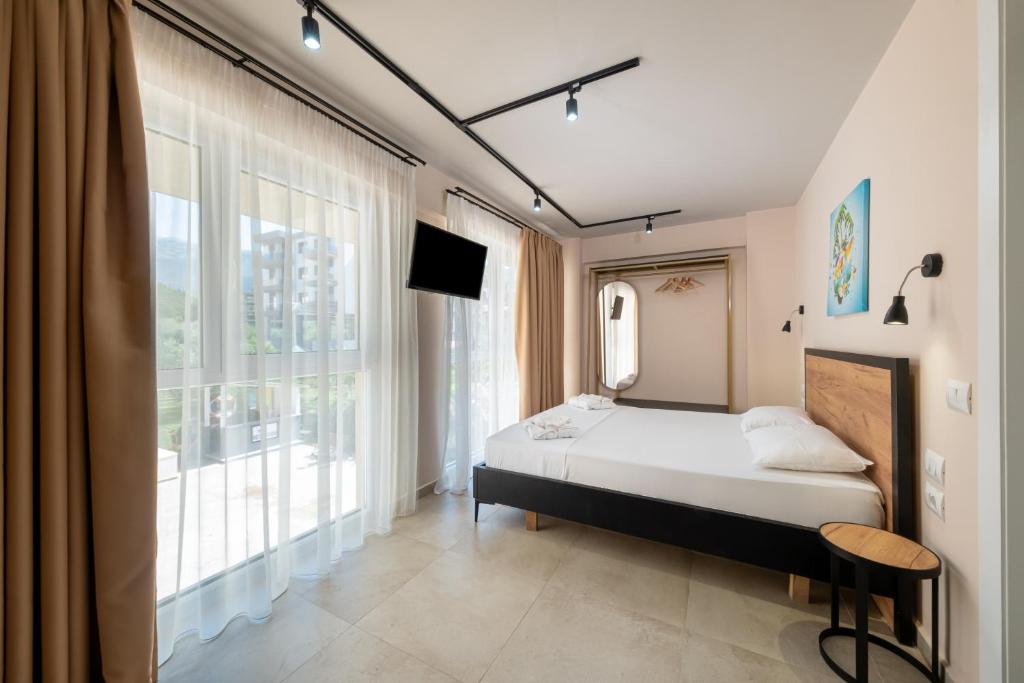 een slaapkamer met een bed en een groot raam bij The Blue Wave Hotel in Himare