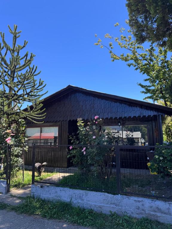 a building with a fence in front of it at Casa Maya Modern central and pet friendly in Futaleufú