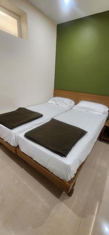 a large bed in a room with a green wall at SRI KRISHNA LODGE in Hosūr