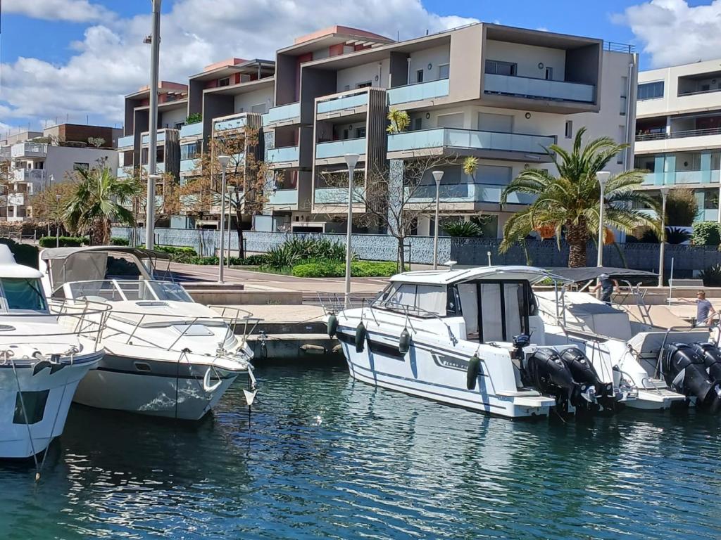 a group of boats docked in the water near a building at Flo location Fréjus in Fréjus