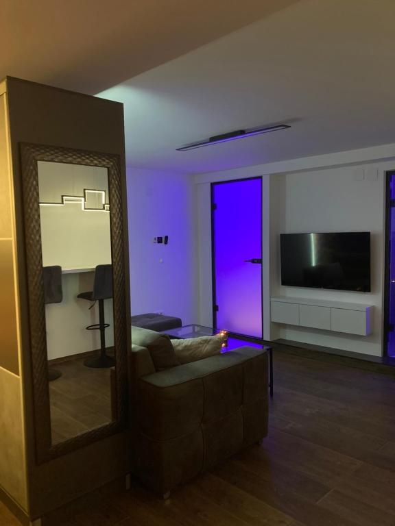 a living room with a couch and a large mirror at Star&spa in Niš