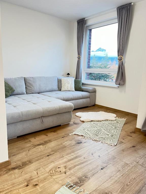 a living room with a couch and a window at Panorama Tatry Apartment in Jezersko