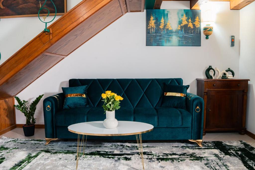 a living room with a green couch and a table at Baroque Residence in Timişoara