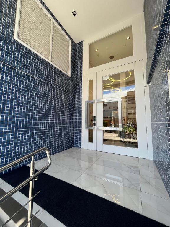 a bathroom with blue tiled walls and a staircase at Apto Home & Club em Capão da Canoa in Capão da Canoa