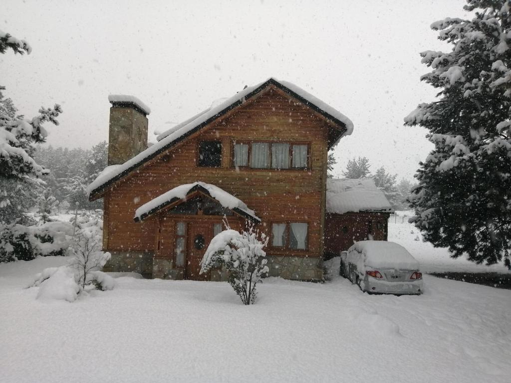 a house with a car parked in the snow at Casa en Bosque de Pinos in San Carlos de Bariloche