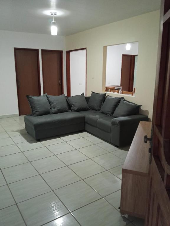 a living room with a black couch in a room at Casa Japaratinga in Japaratinga
