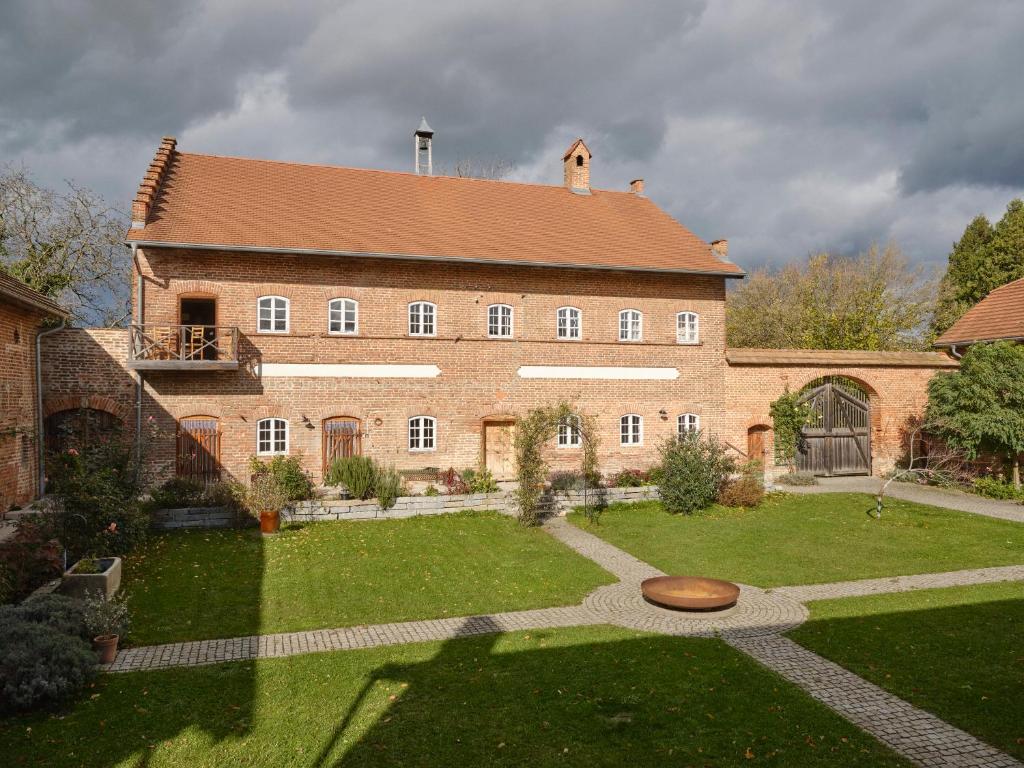 a large brick building with a garden in front of it at Denharten in Tann