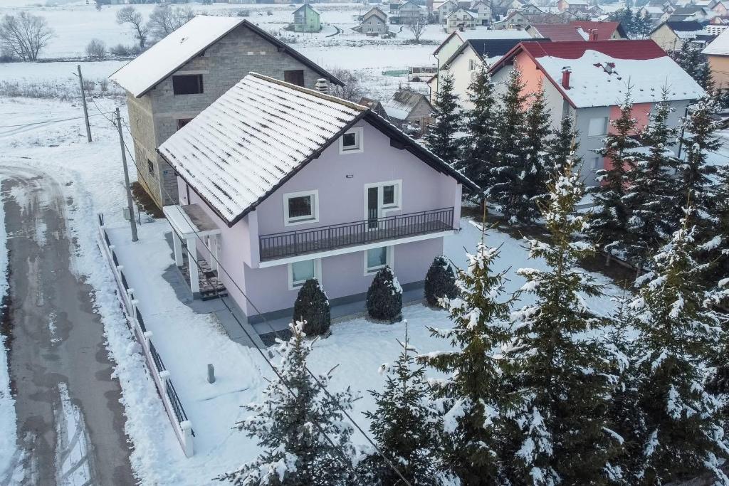 a white house in the snow with trees at Biser Kupresa 2 in Kupres