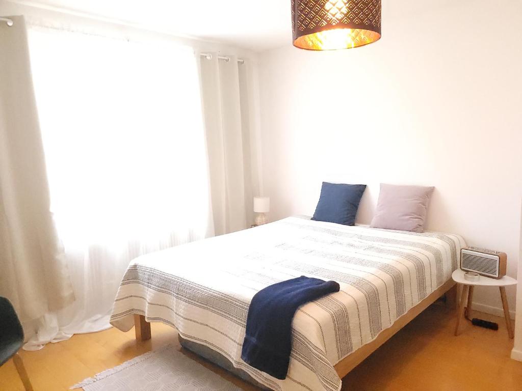 a bed in a room with a large window at Chambre double privée in Martigny-Ville