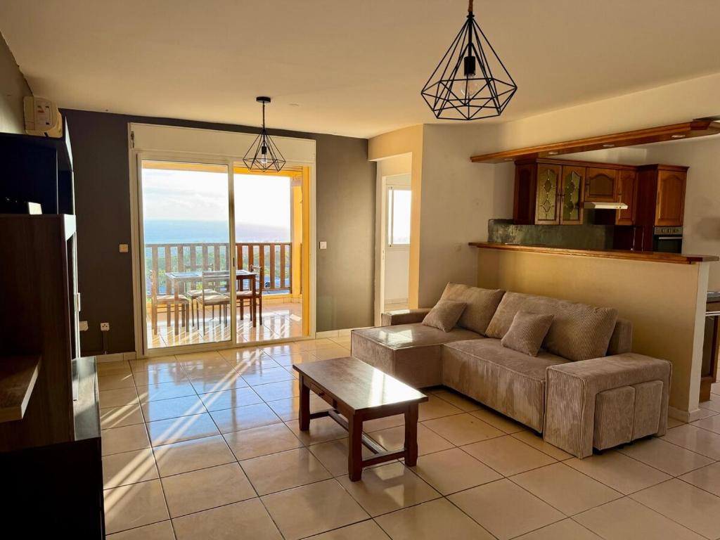a living room with a couch and a table at Apartment with exceptional views, Saint-Joseph in Saint-Joseph
