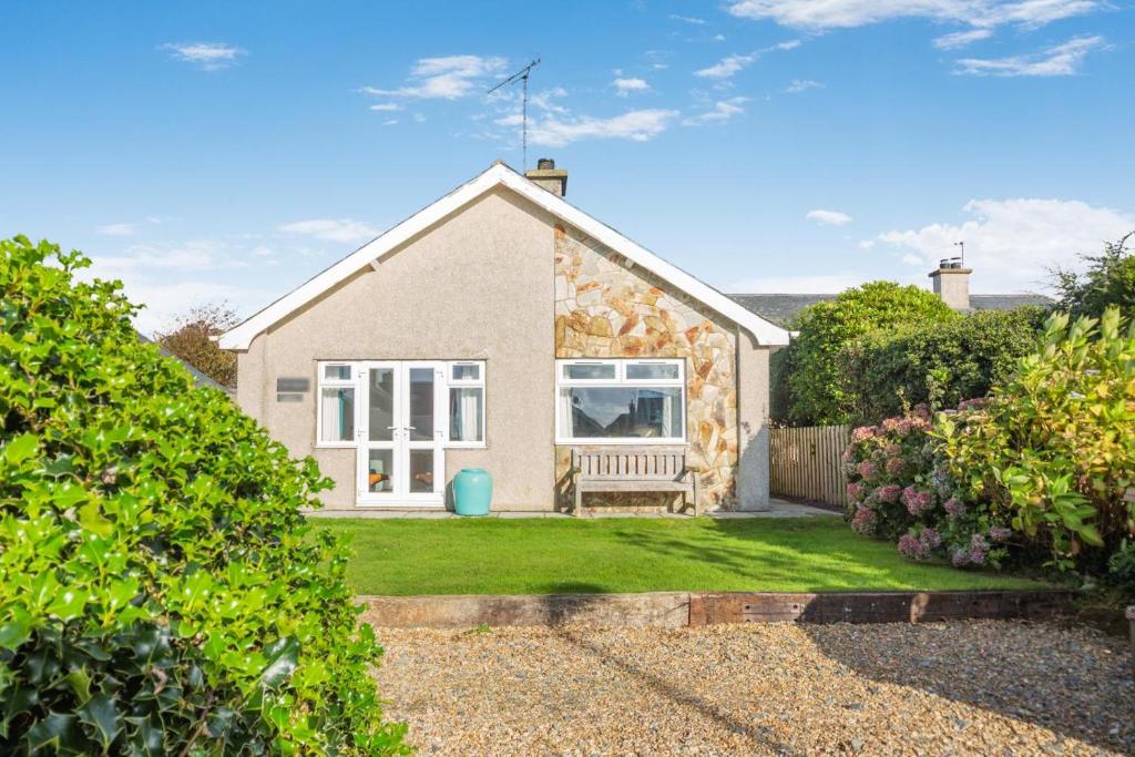 a stone house with a bench in a yard at 3 Bed in Morfa Nefyn oc-wag720 in Morfa Nefyn
