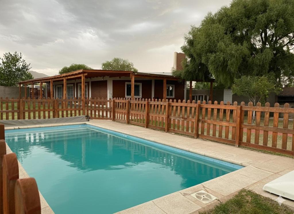 een zwembad met een houten hek en een huis bij CASA COMPLEJO LoS PRIMOS in Pozo del Carril