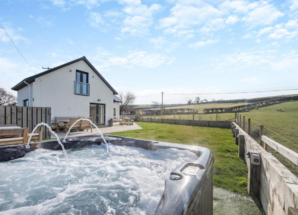 a hot tub in a yard next to a house at 4 Bed in Aberarth oc-g30835 in Aberaeron