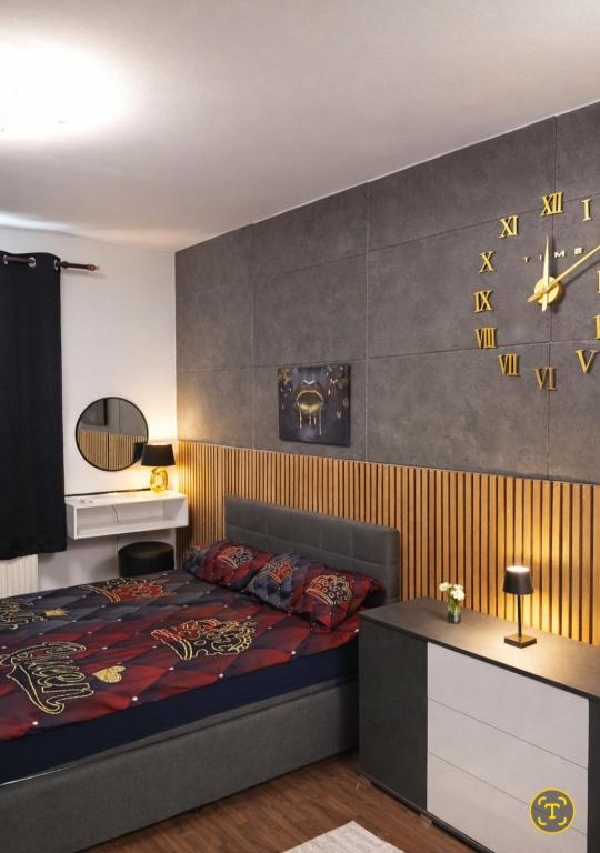 a bedroom with a bed and a wall with clocks at Midnight Crown Suite in Hannover