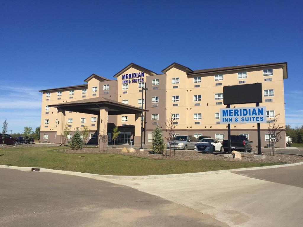 un gran edificio con un cartel para un hotel en Meridian Inn & Suites Lloydminster, en Lloydminster